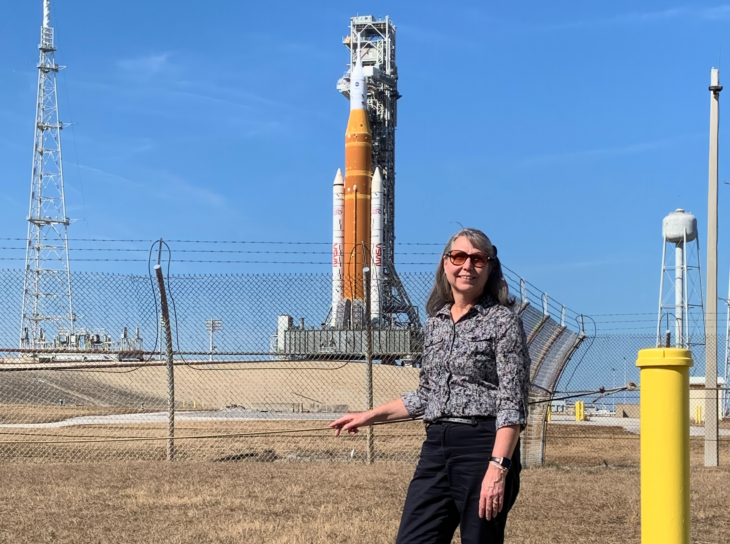 One member standing in front of a rocket ship
