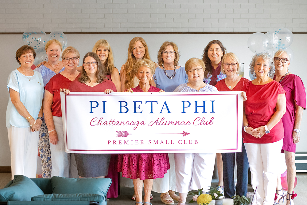 Several members standing behind a banner that says Pi Beta Phi Chattanooga Alumnae Club Premier Small Club