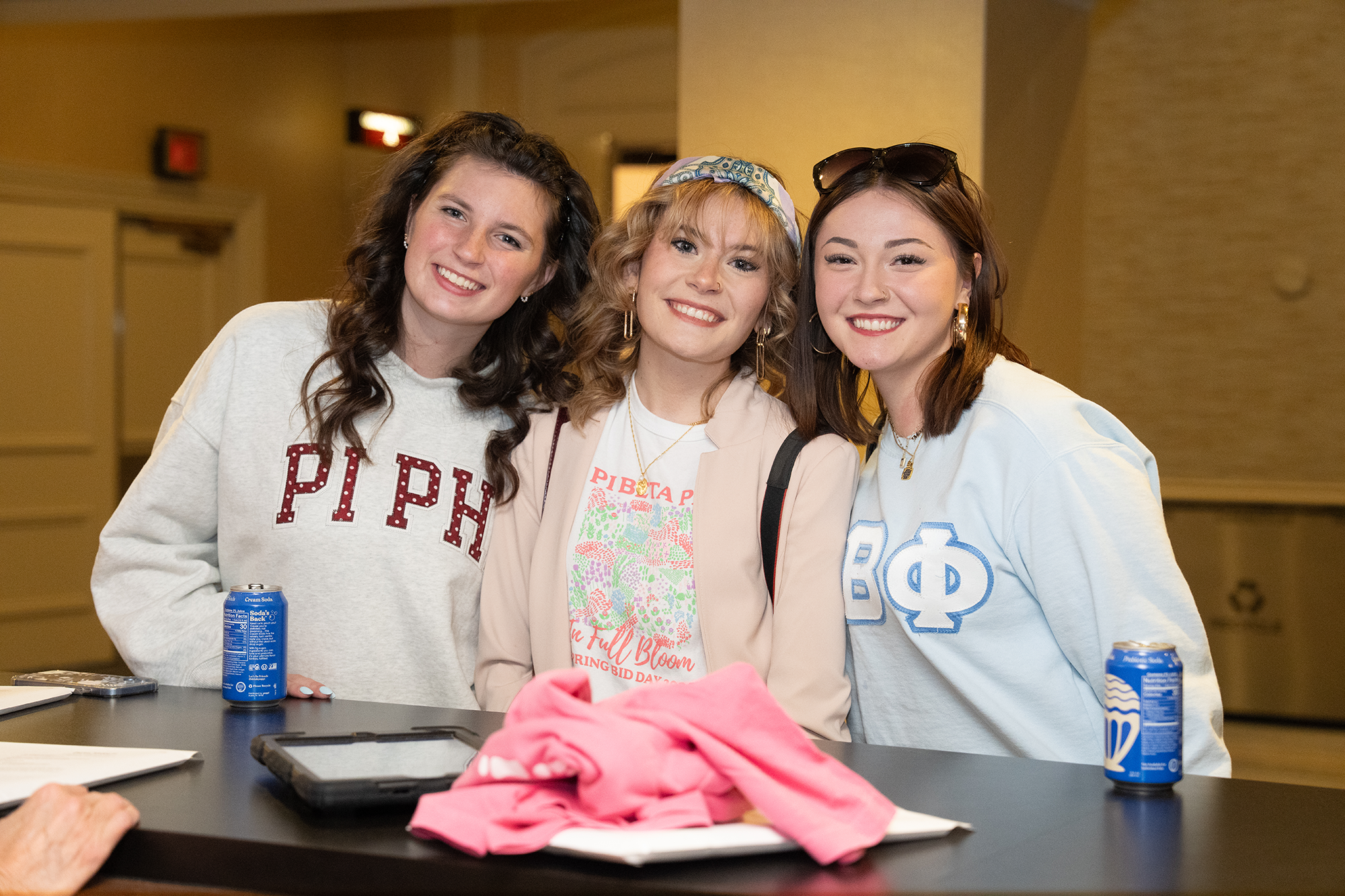 Three members wearing Pi Phi sweatshirts