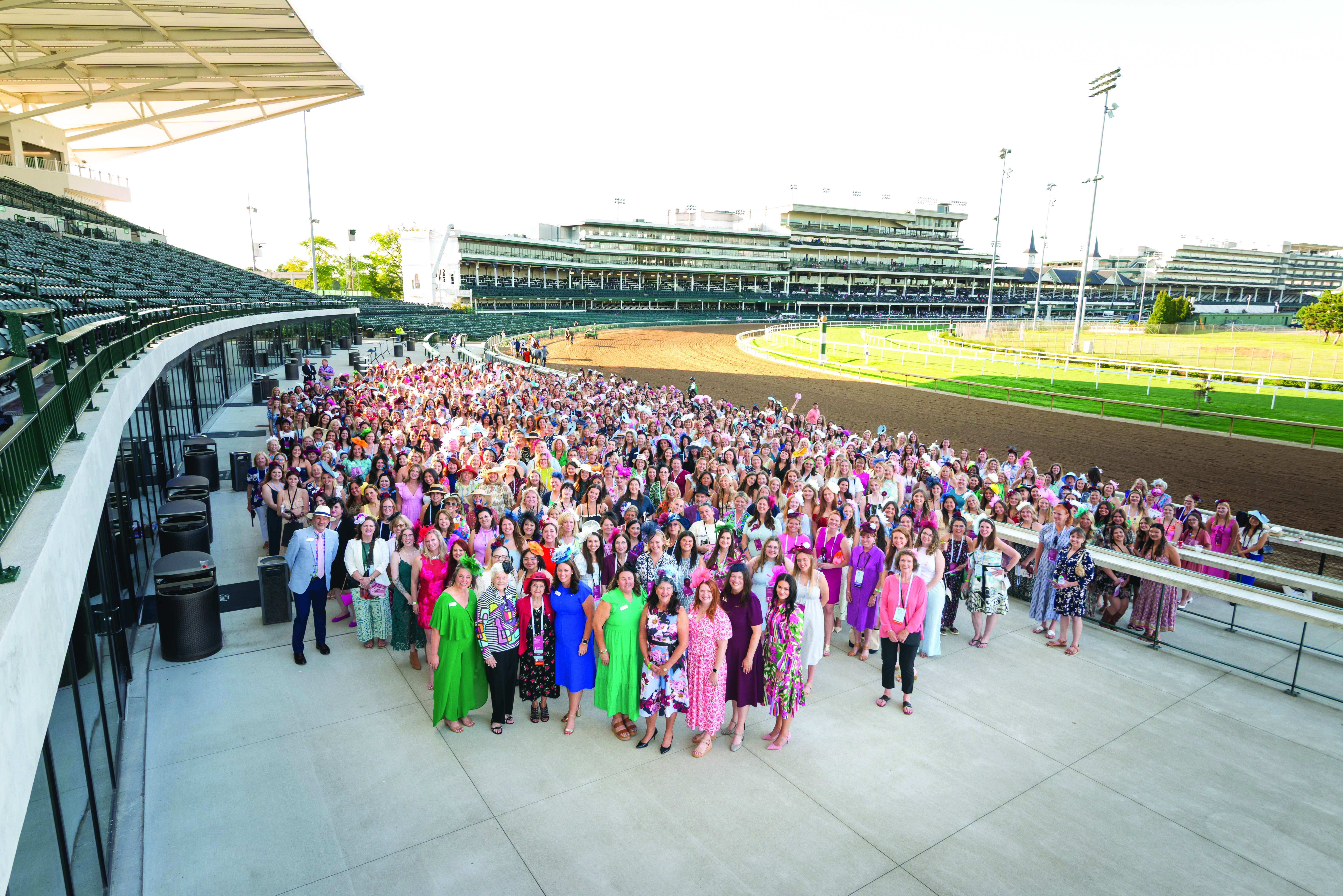 A group of individuals standing beside a horse racetrack