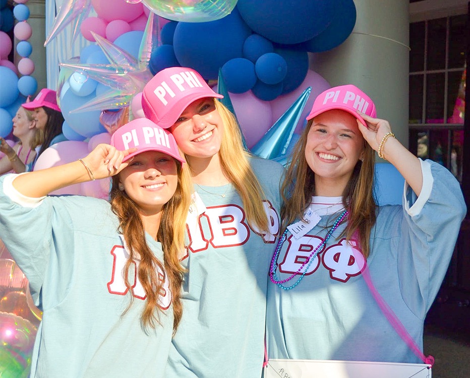 Three people standing outdoors wearing Pi Phi apparel