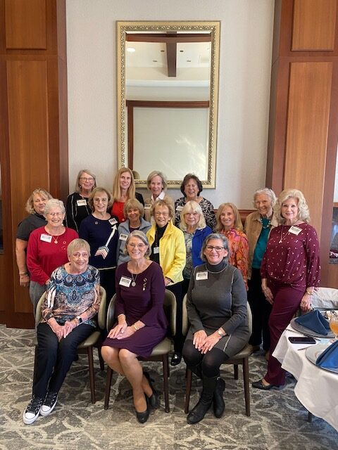 Several alumnae members posing inside in front of a large door