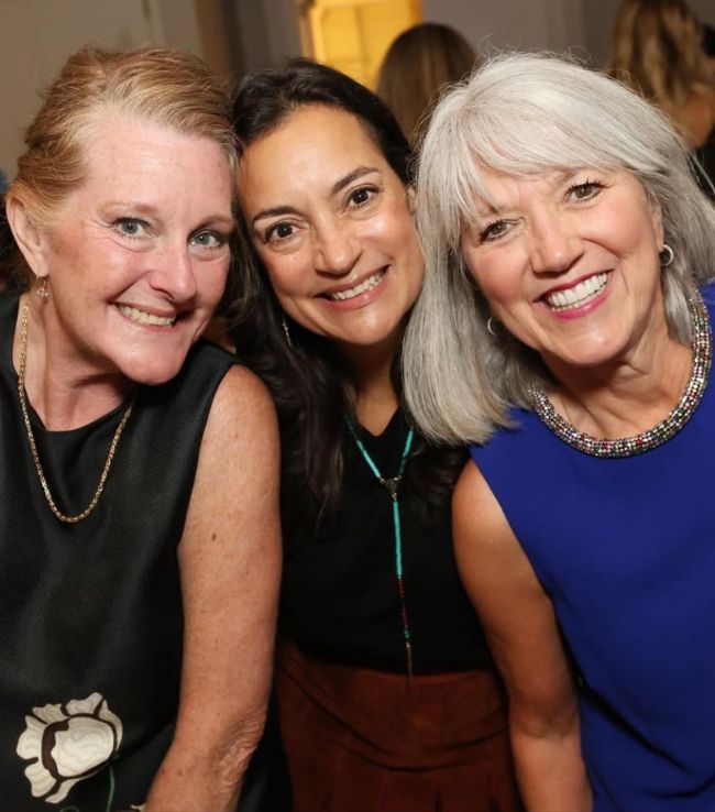 Three Pi Beta Phi alumnae smiling together at an evening event