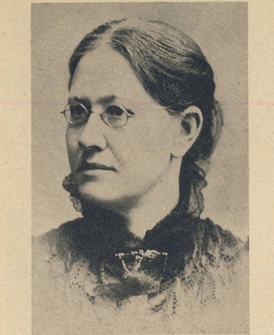 Black and white historical portrait photograph of a Pi Beta Phi founder wearing glasses and a dark Victorian-era dress