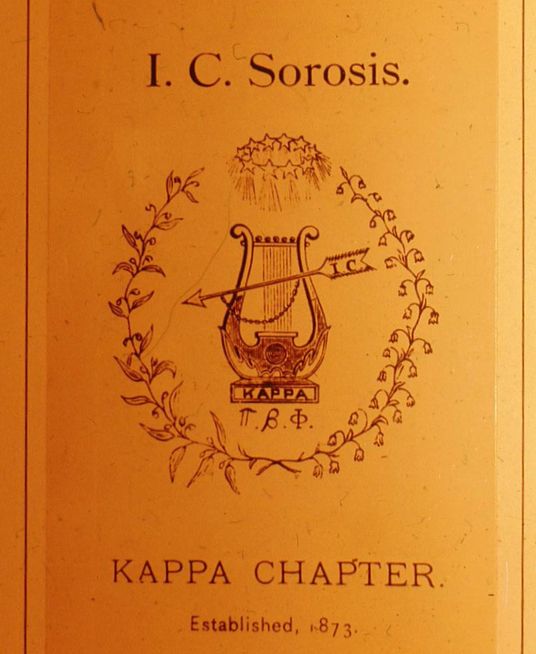 Historical document cover for I.C. Sorosis Kappa Chapter established in 1873 featuring a decorative crest with a lyre and arrow emblem