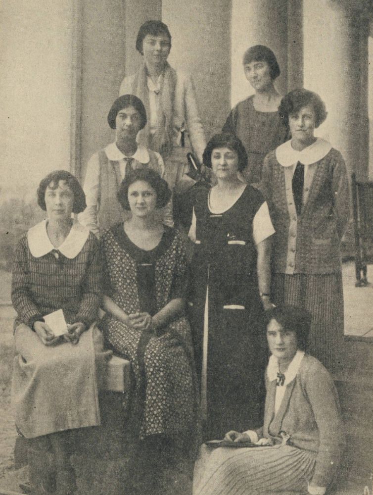 Sepia-toned historical group portrait of eight Pi Beta Phi members posed in front of large columns in 1920s era clothing