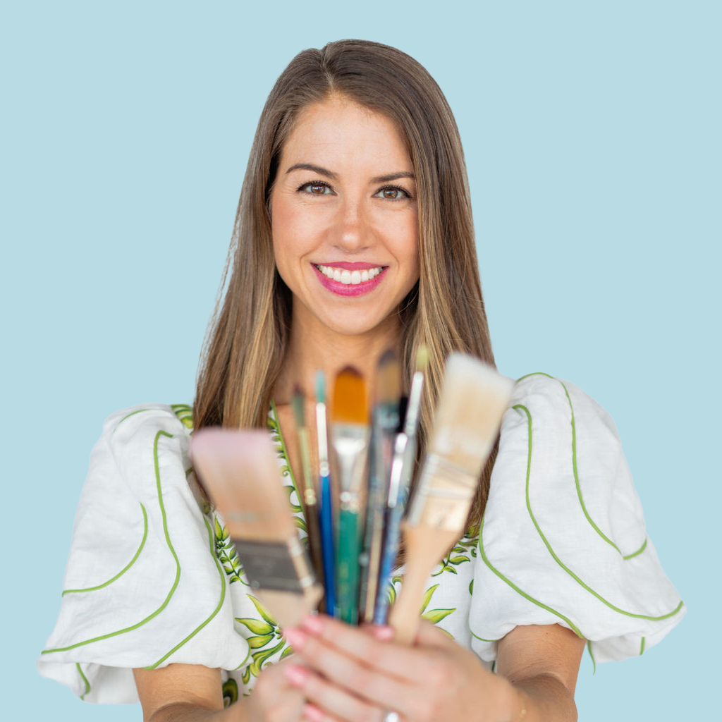 Professional headshot of Stephanie Troxler holding paint brushes