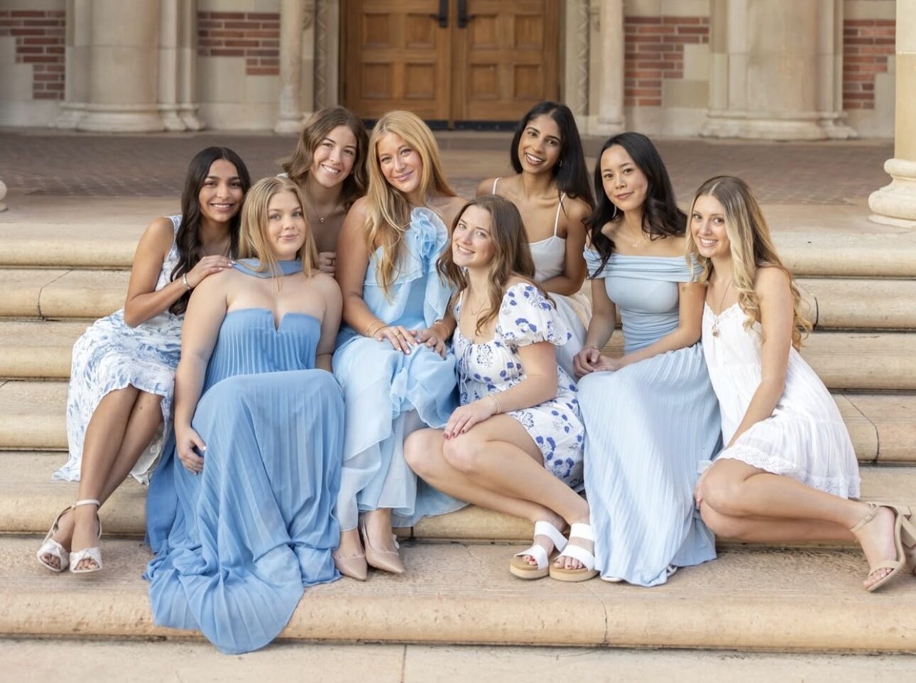 Eight individuals sitting on a staircase outdoors