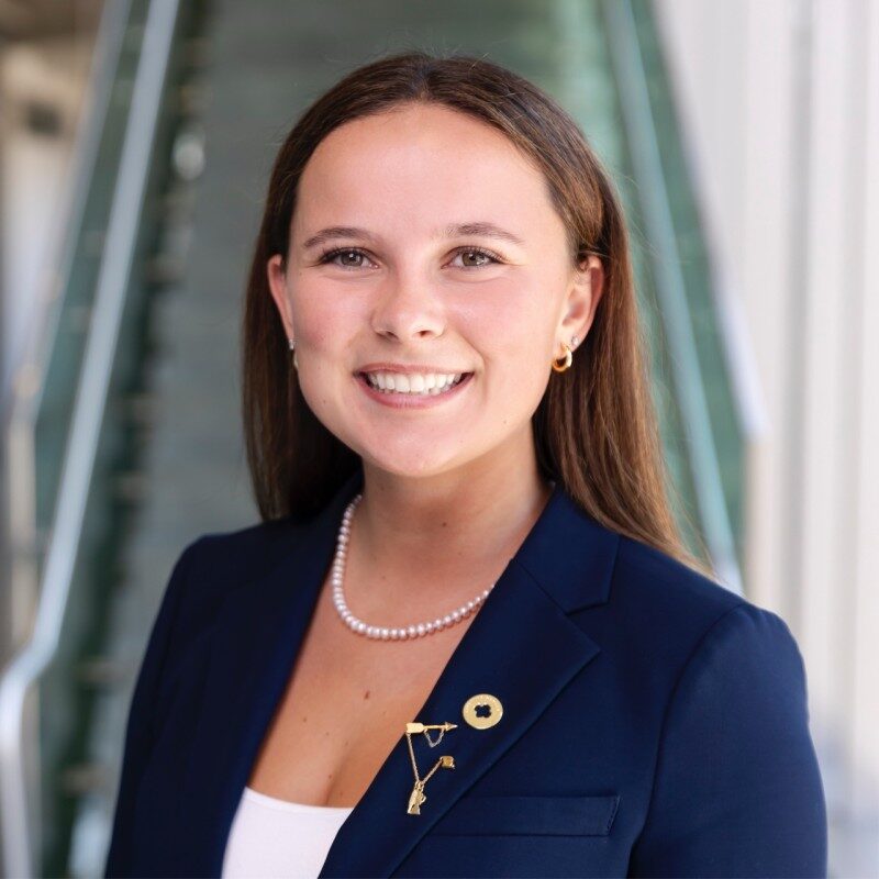 Professional headshot of Sydney Scott wearing a navy blazer and white blouse