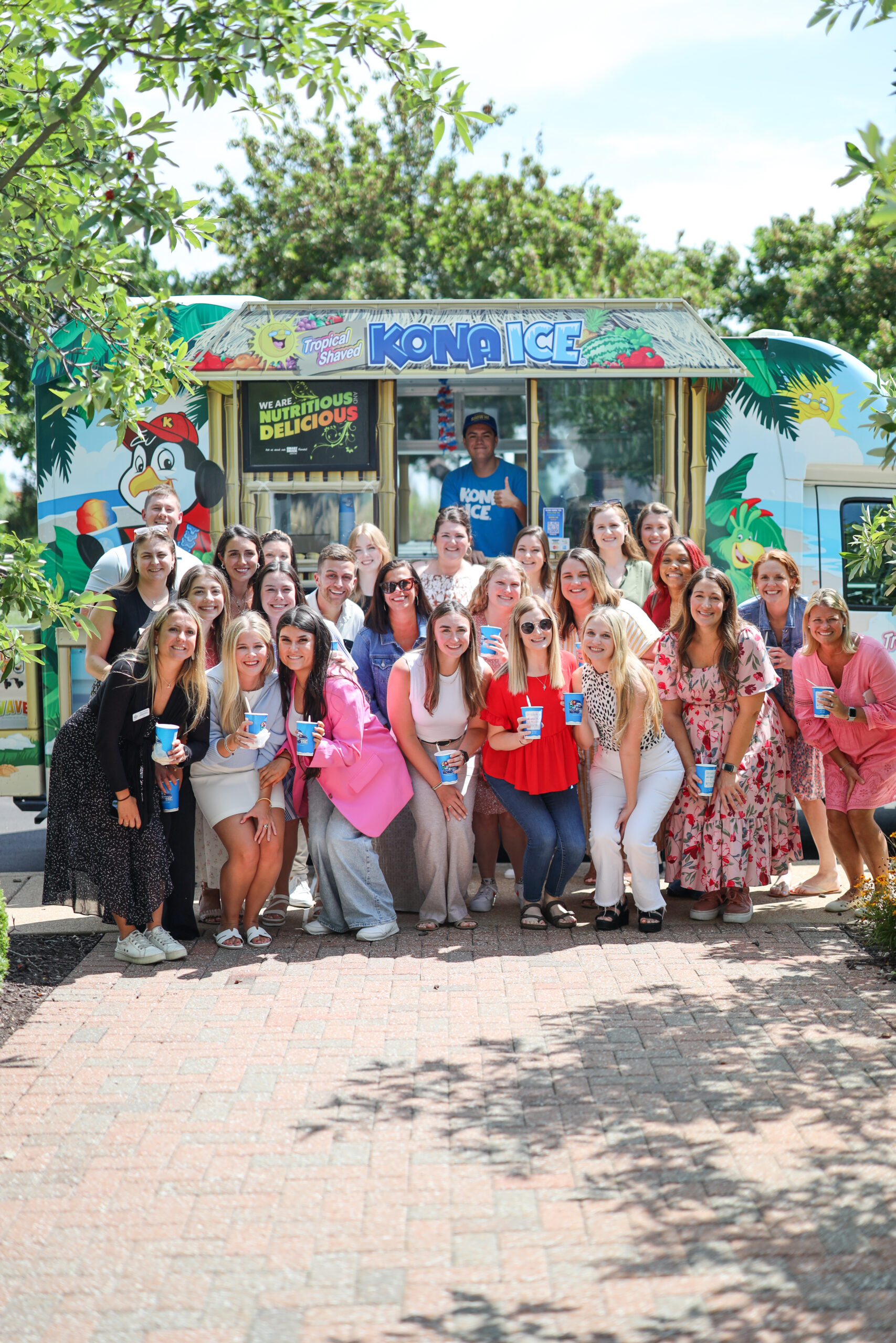 A large group of members standing outside in front of a blue ice cream truck