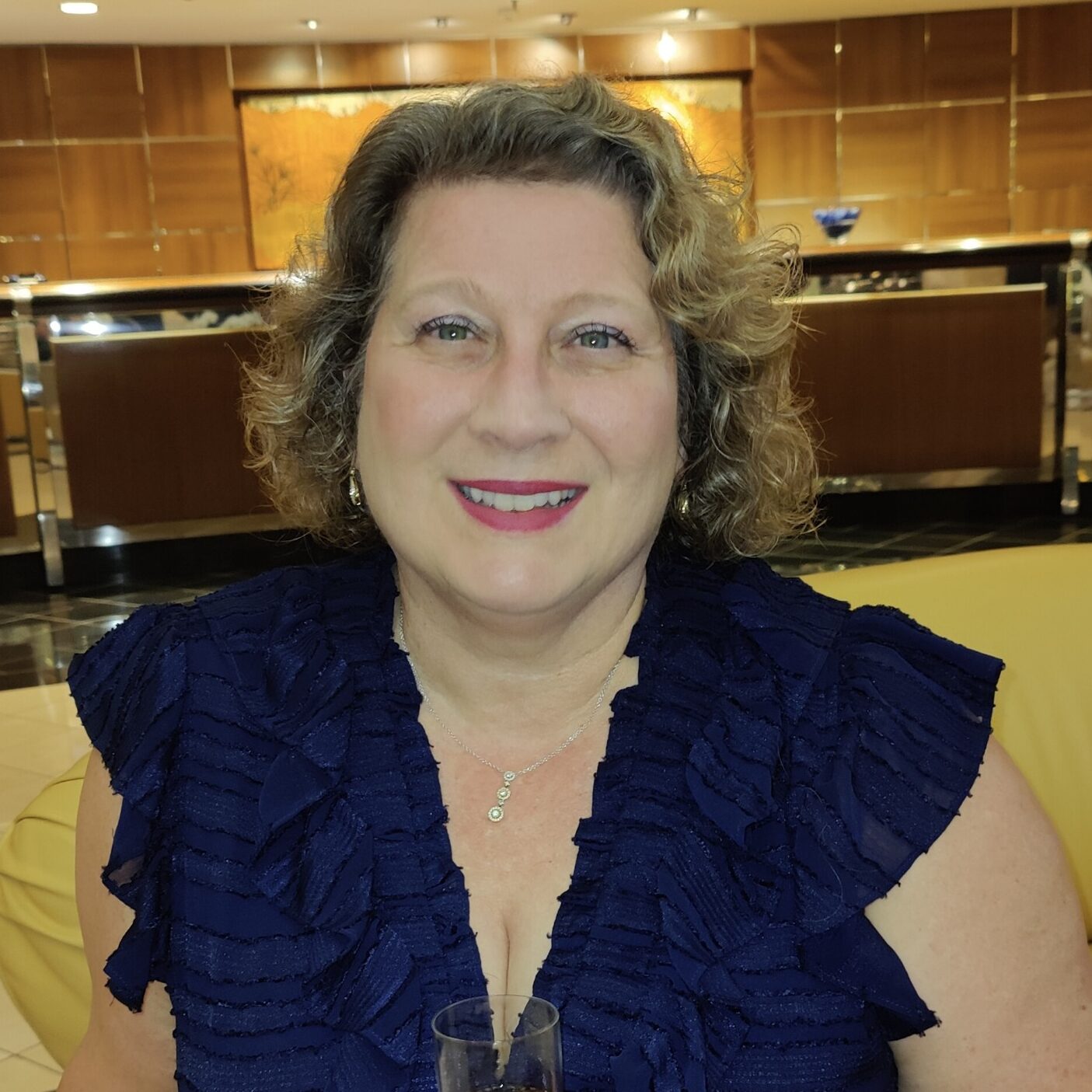 Headshot of Angie Underwood wearing a black blouse sitting in a hotel lobby