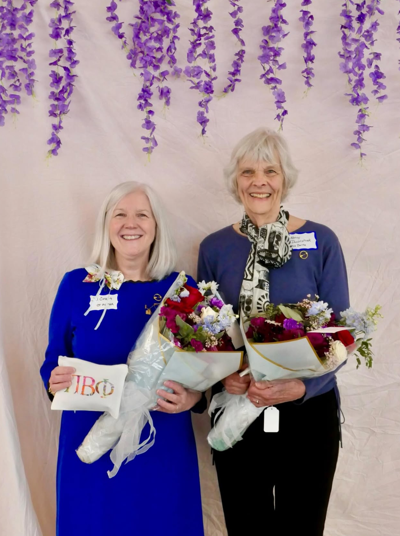 Two individuals holding bouquets of flowers