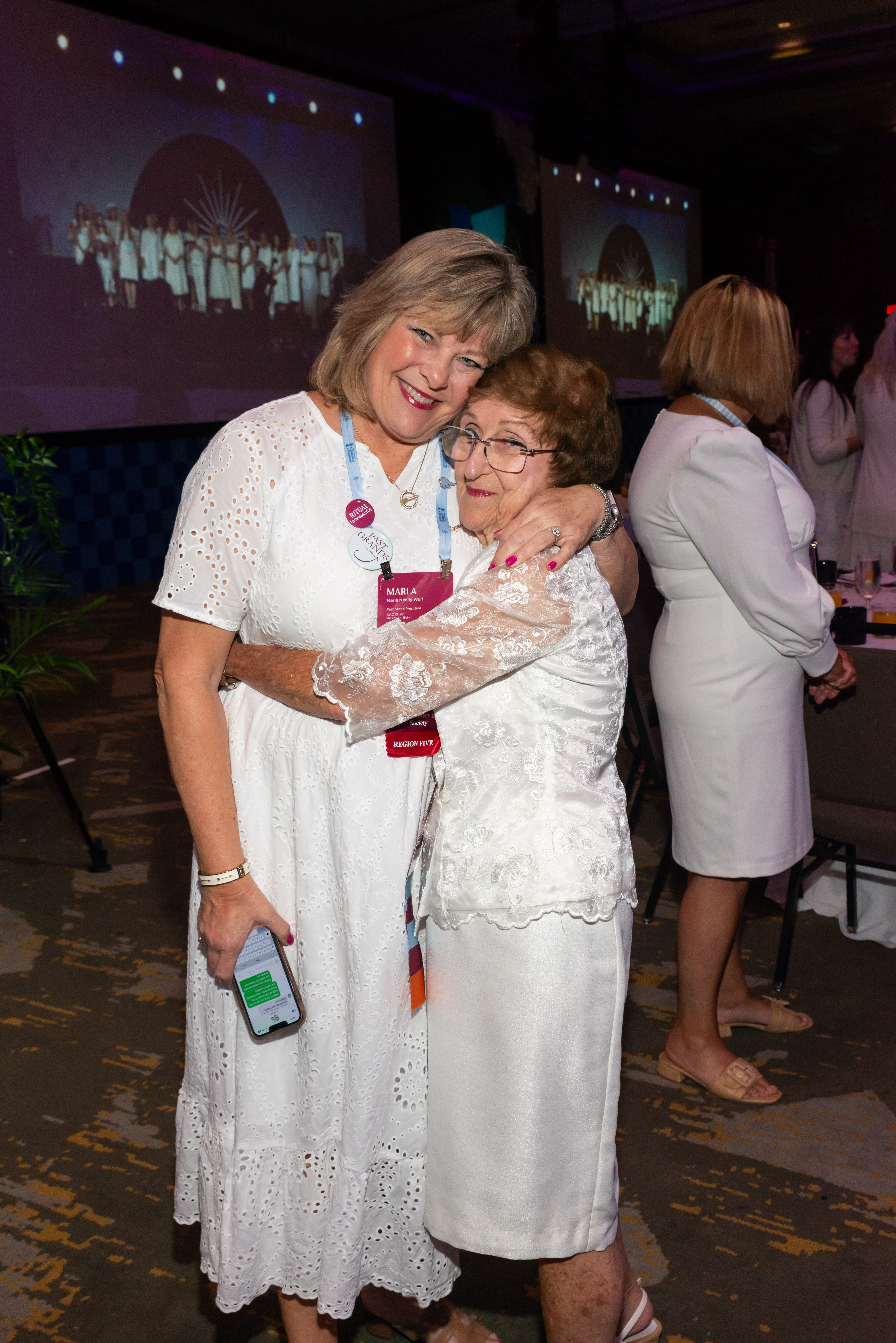 Two individuals hugging and wearing white