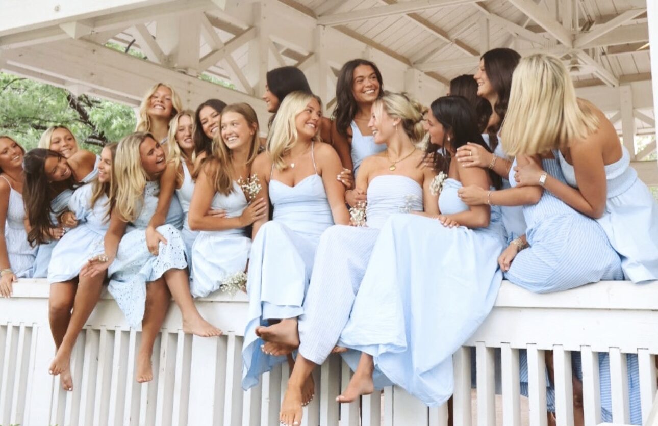 Several members sitting on a balcony wearing silver blue dresses