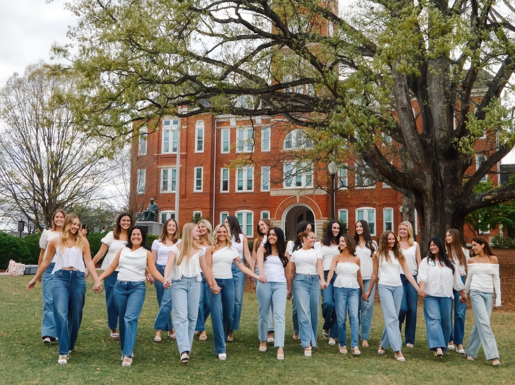 A group of members wearing white shirts and blue jeans walking toward the camera