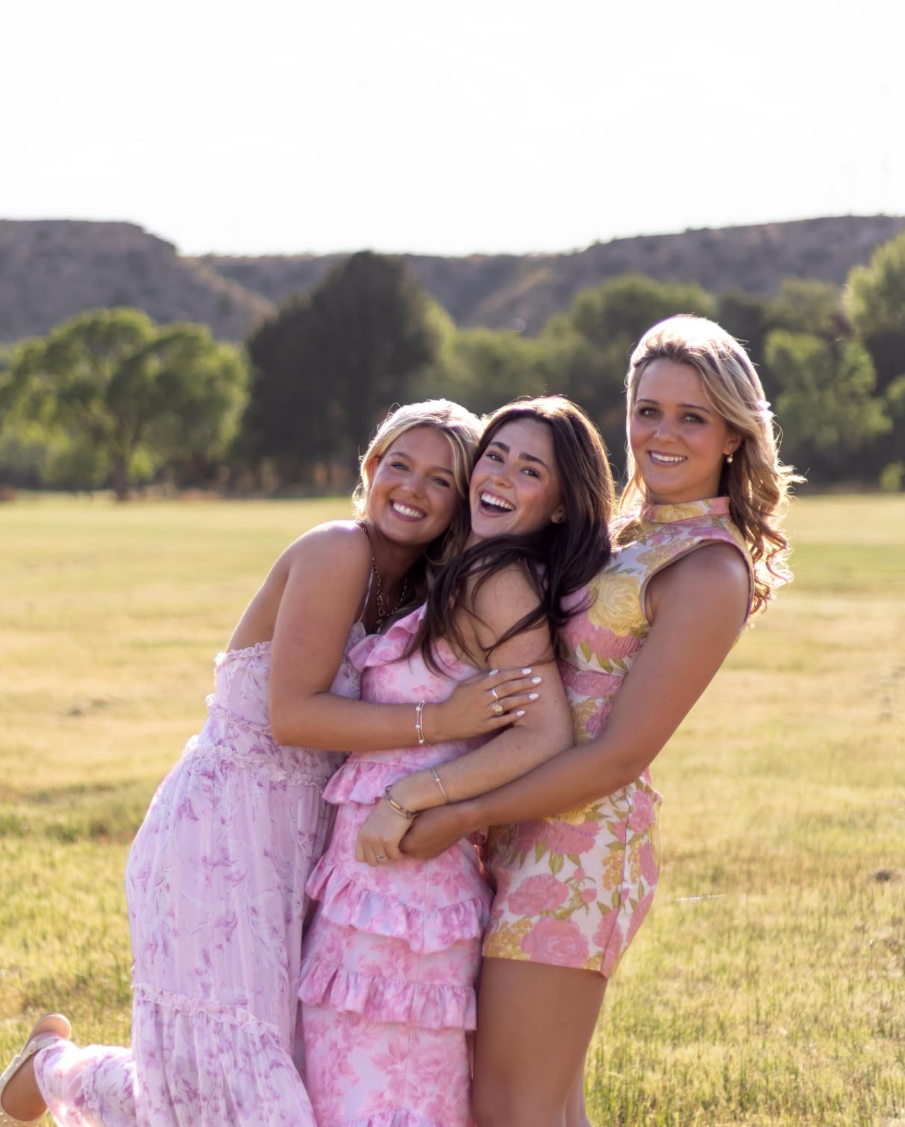 Three individuals standing in a grassy field