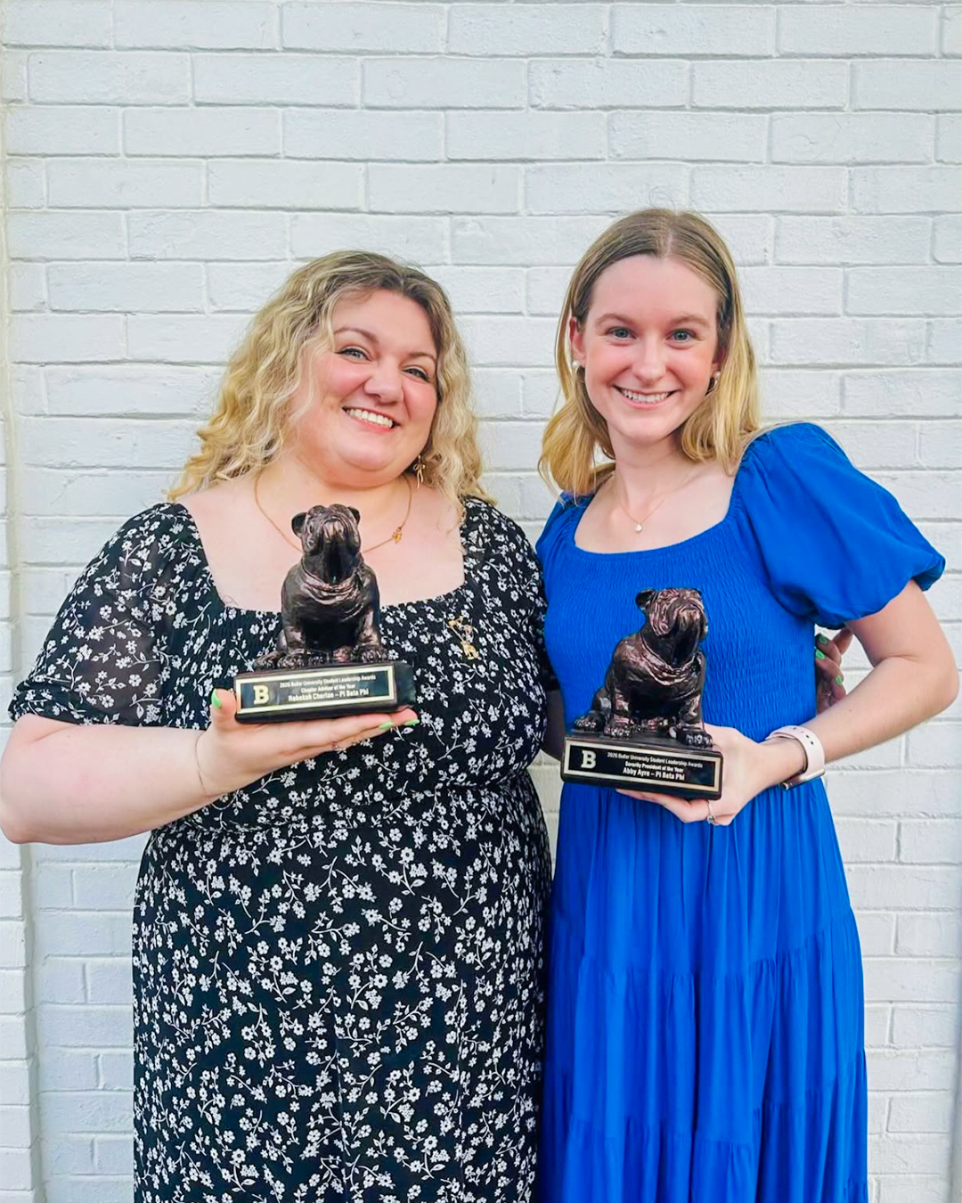 Two members holding trophies