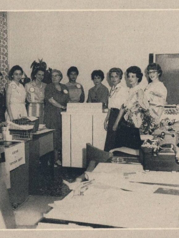 Several members of Convention Daily staff standing around a podium