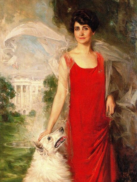 Portrait of Grace Goodhue Coolidge wearing a red dress and petting a white dog in front of the White House