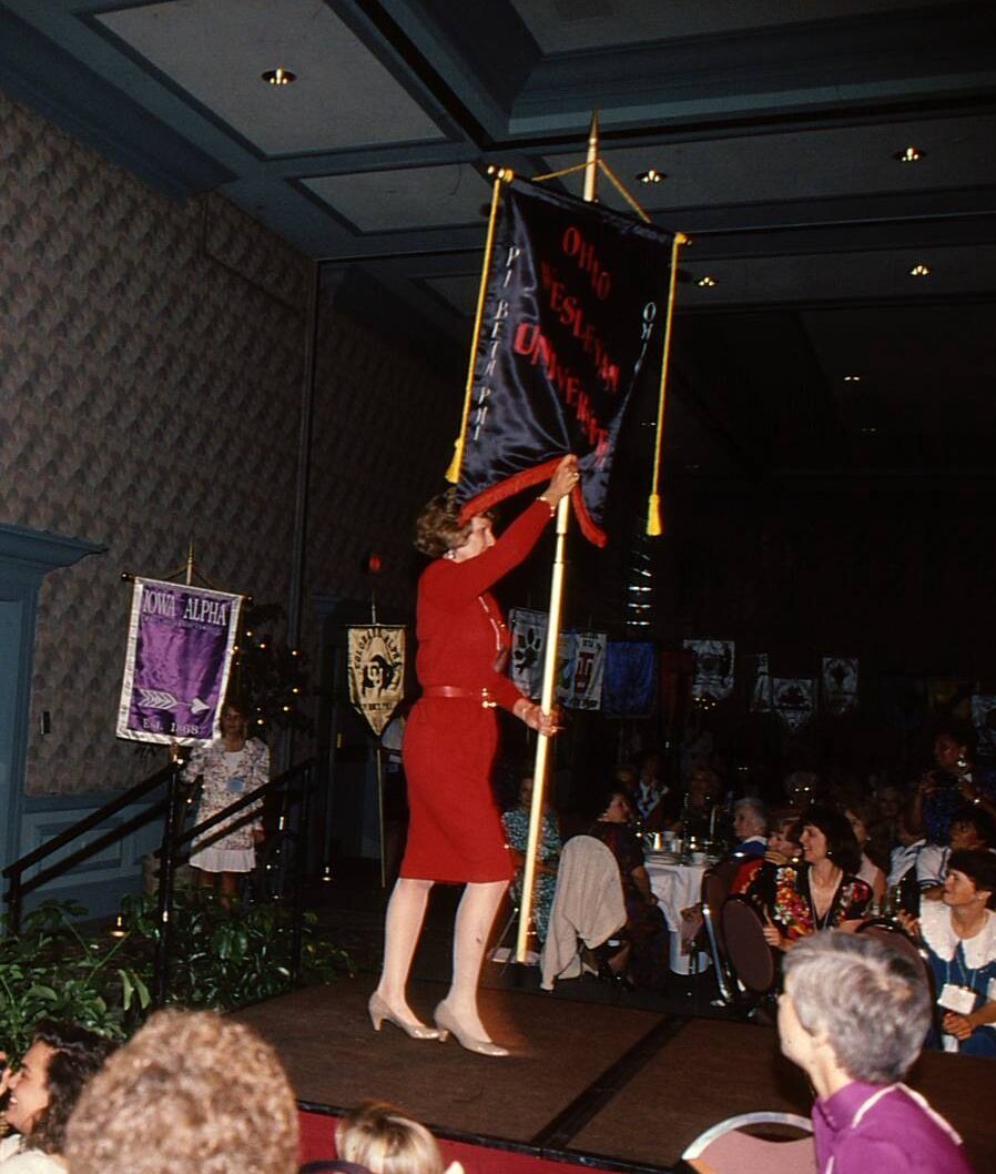 One member holding a banner and walking on a stage