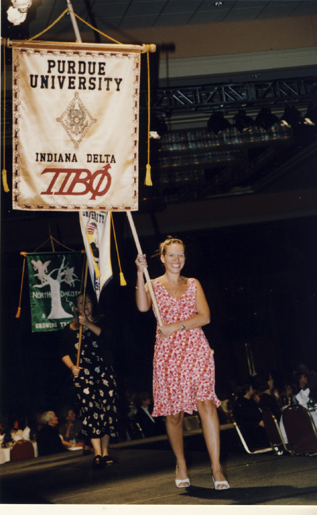 One member holding a banner that says Purdue University and walking