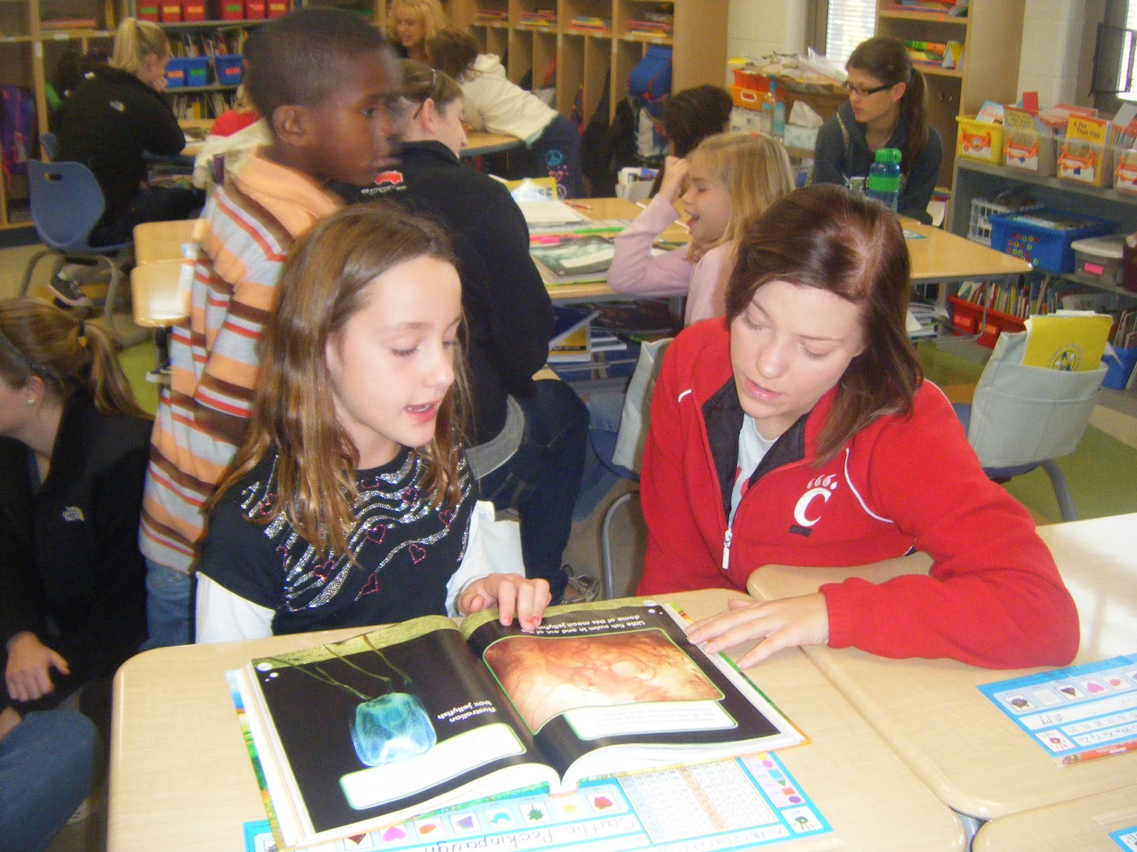 A member reading with a child in a classroom