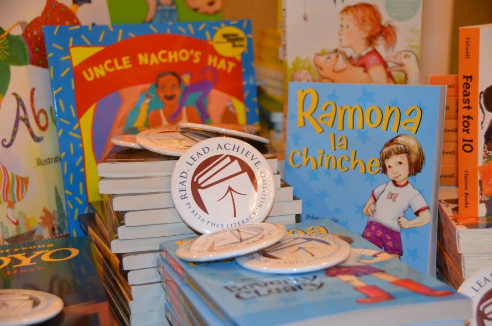 A button that has the Read Lead Achieve logo sitting on top of books