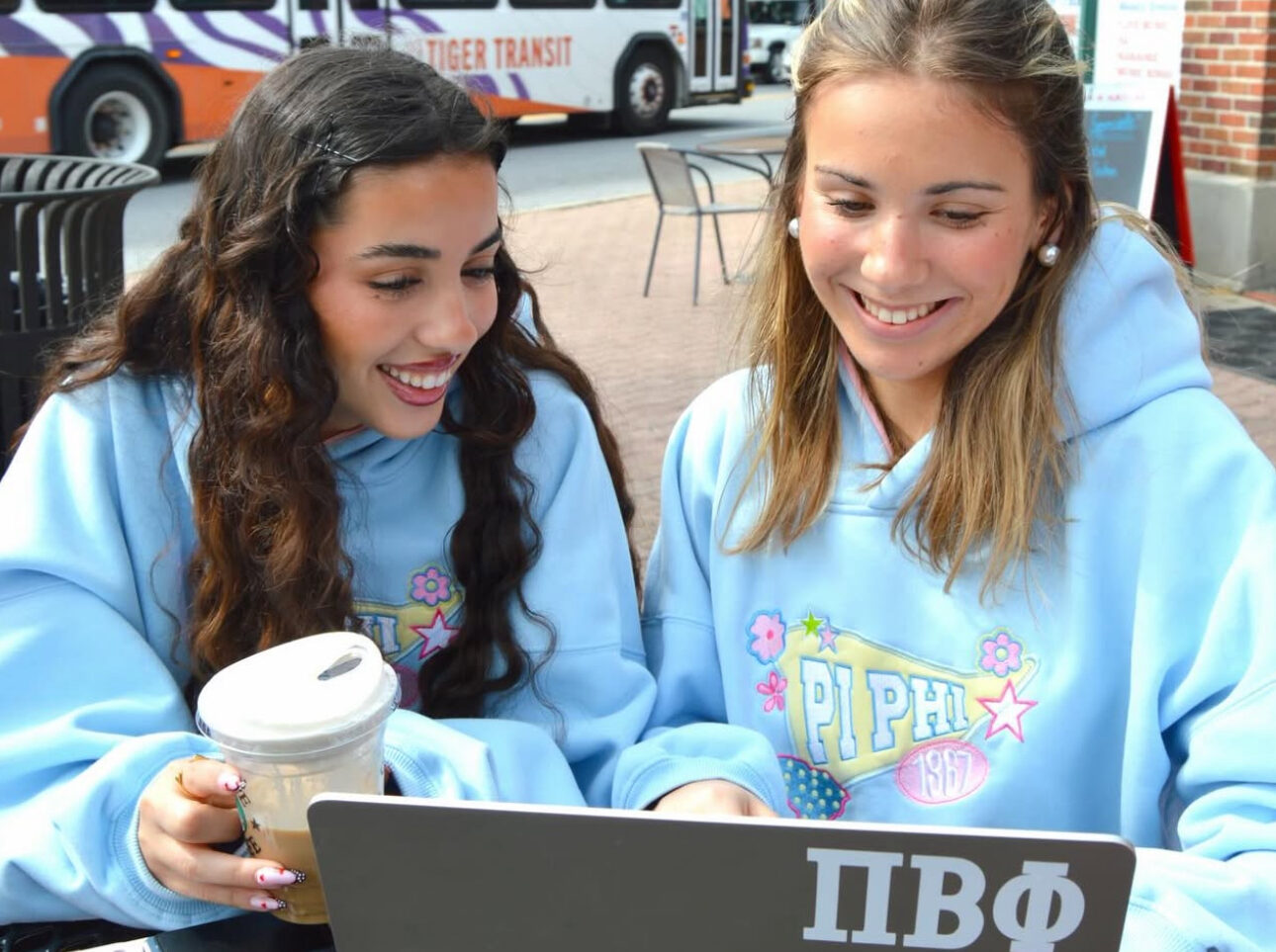 Two members sitting in front of a laptop
