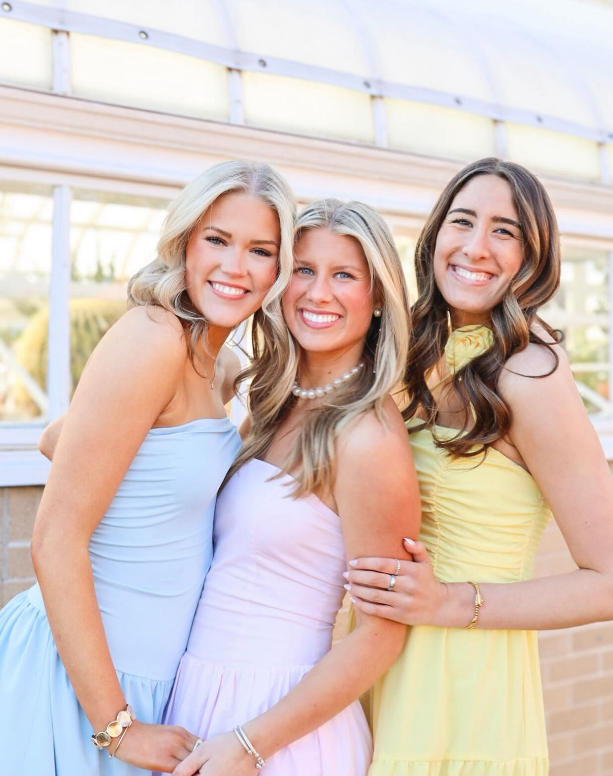 Three individuals standing and hugging