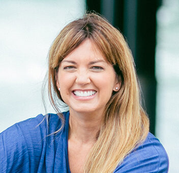 Professional headshot of Jane Porter wearing a blue shirt posing outdoors