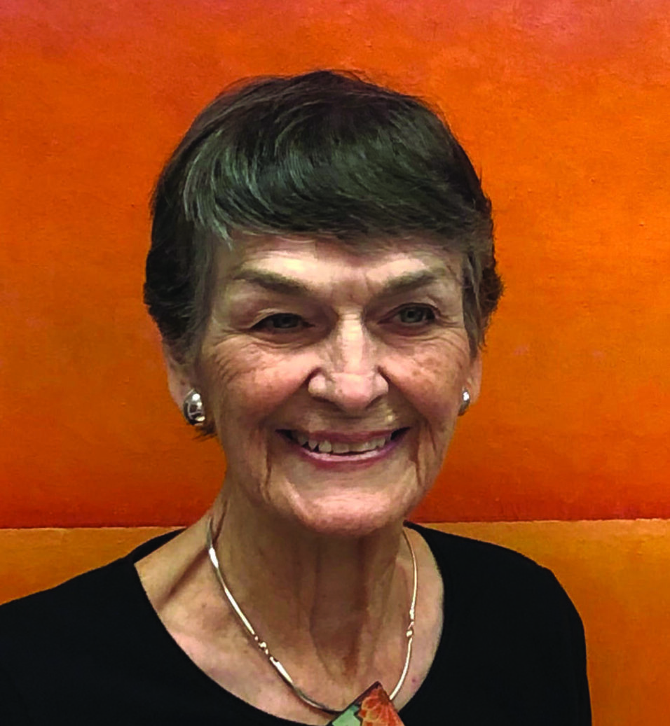 Headshot of Janet Rogers wearing a black shirt in front of an orange background