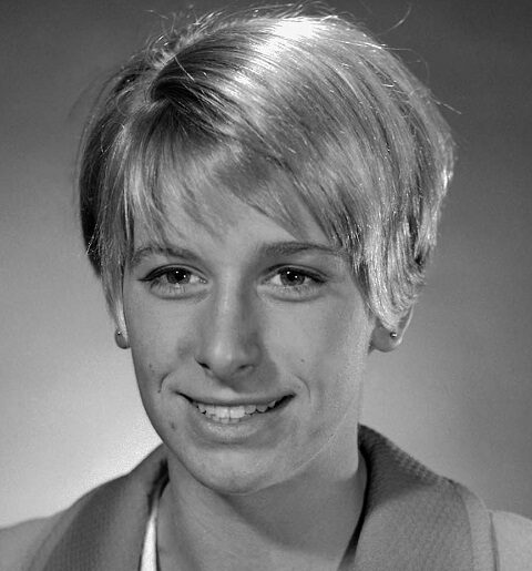 Black and white professional headshot of Kaye Hall Greff wearing a blazer in front of a grey background