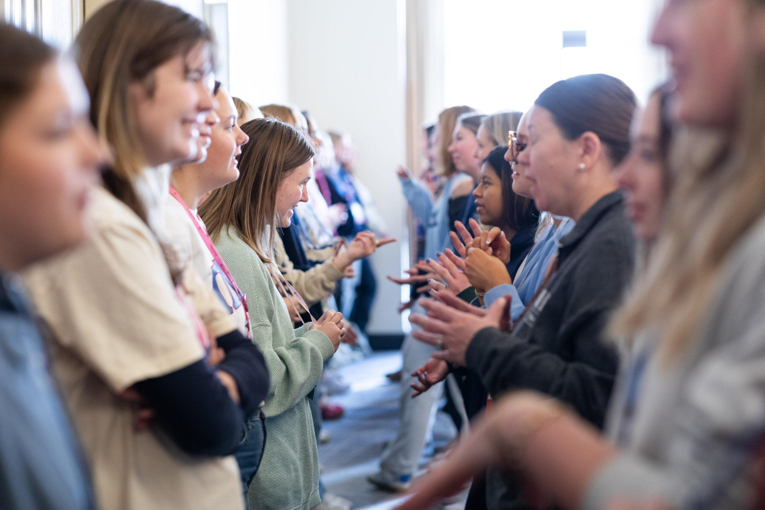 A group of individuals standing in a line and talking to one another