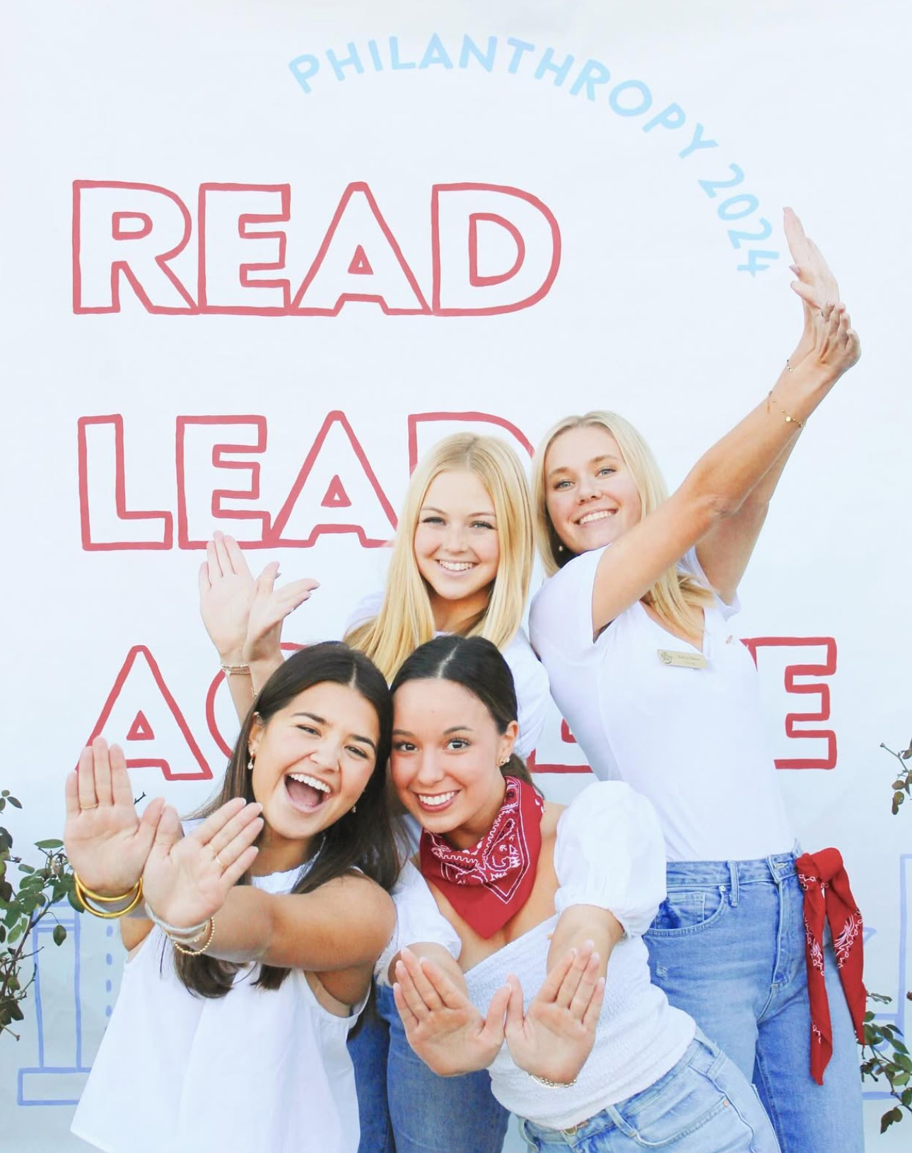Four individuals standing in front of a banner that says Read Lead Achieve