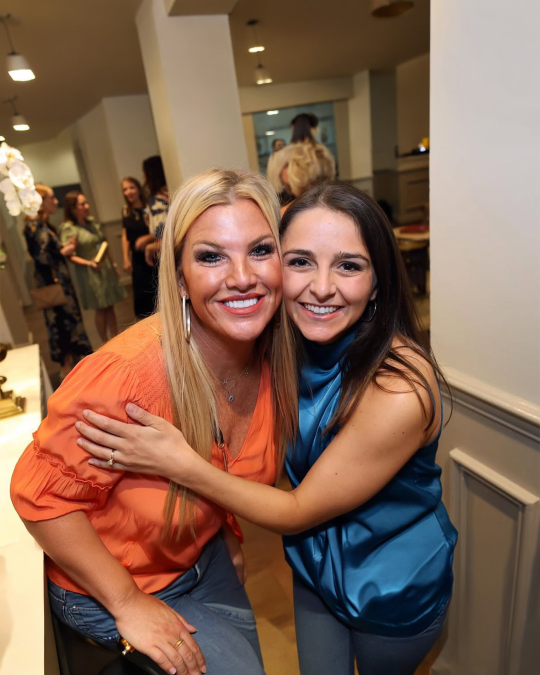 Two individuals hugging indoors