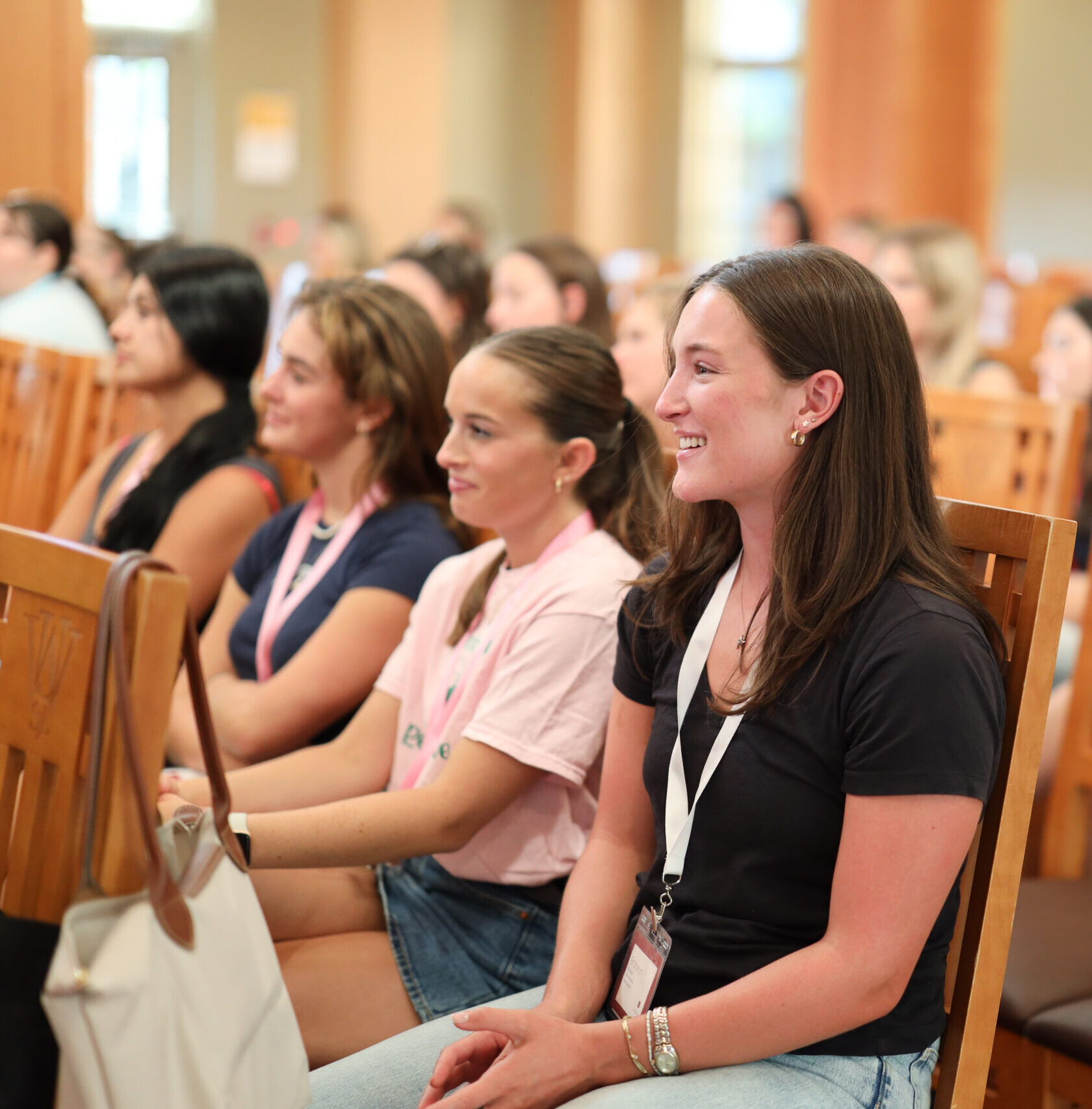 Several members sitting in wooden chairs listening
