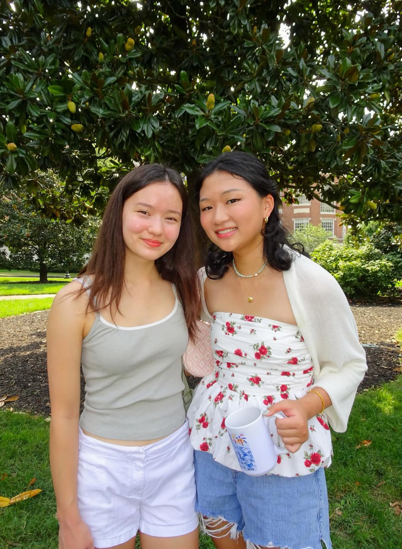 Two members standing in front of a tree
