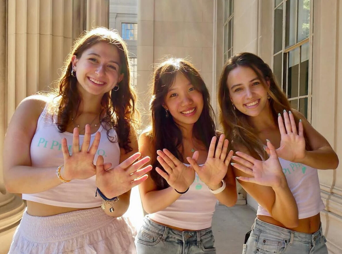 Three members making angel wings with their hands