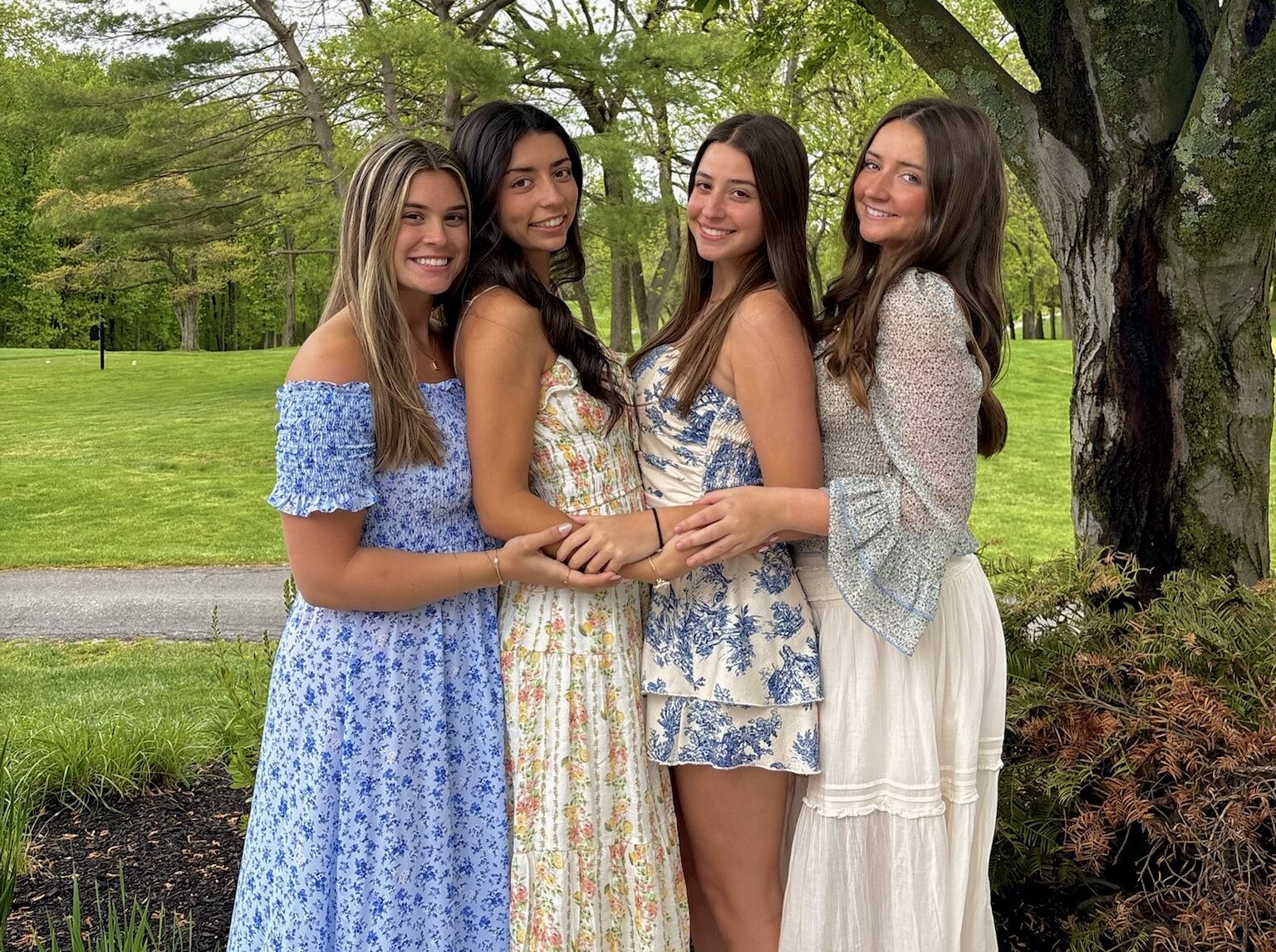Four members standing under a tree