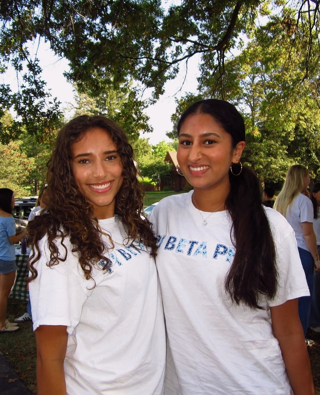 Two members standing under a tree
