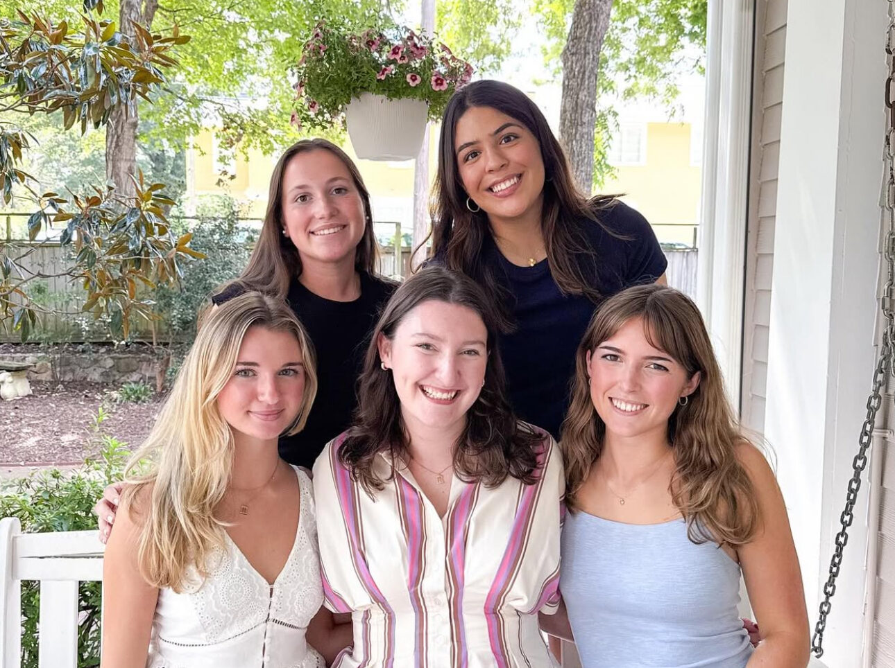 Five members sitting on a front porch