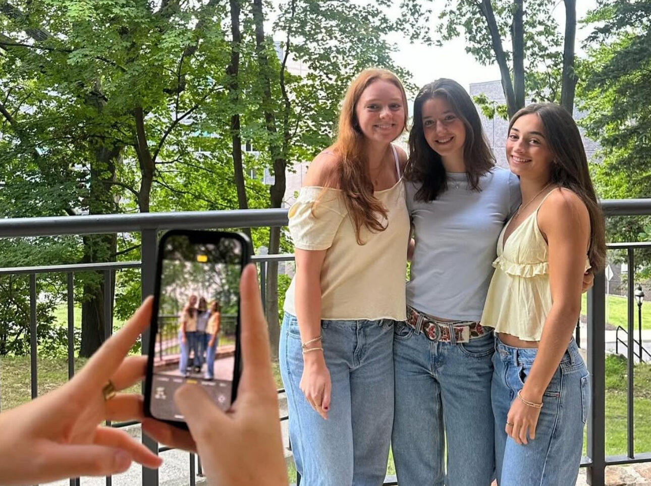 Three members posing for a photo and another member taking the photo