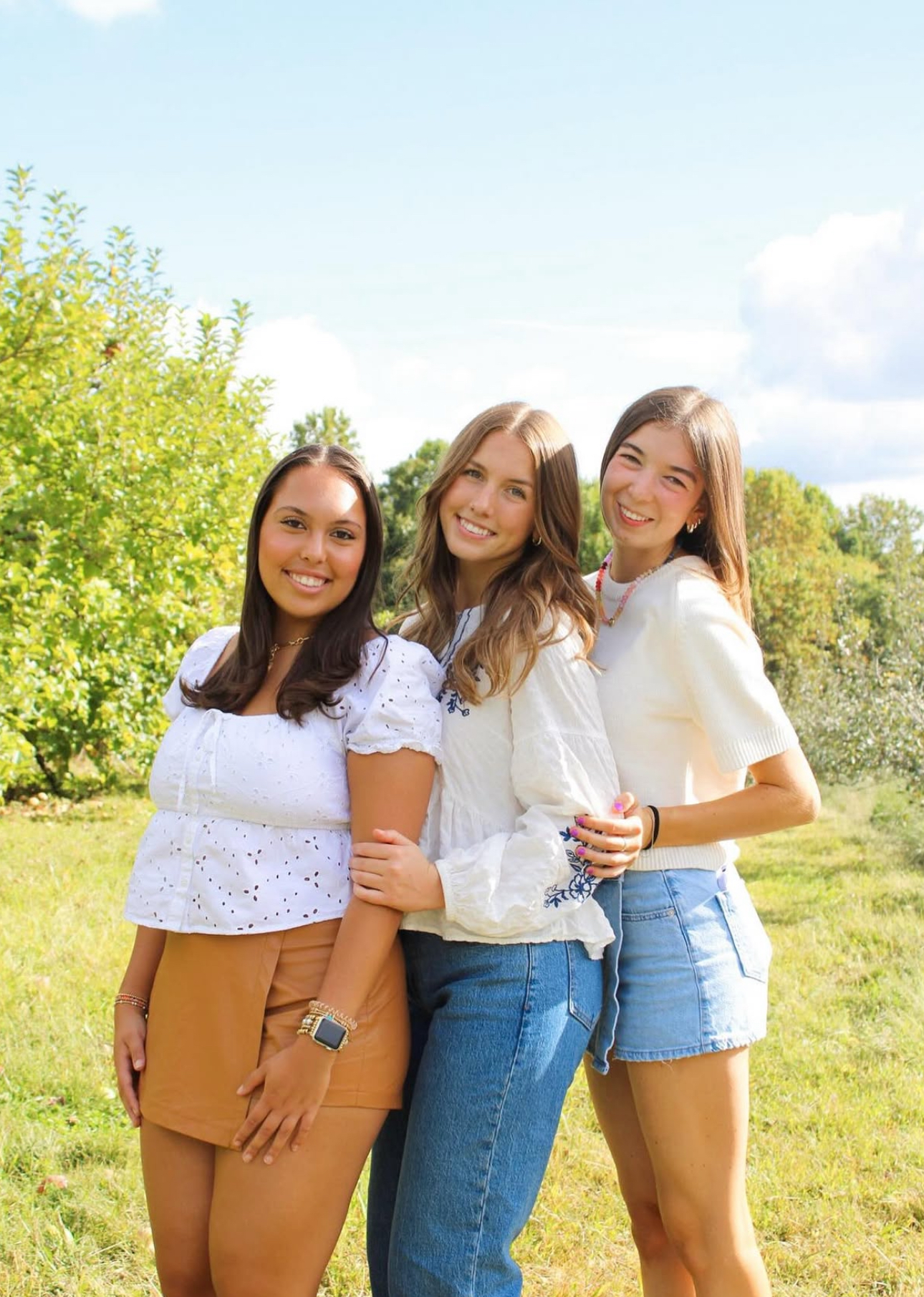 Three members standing in a green field