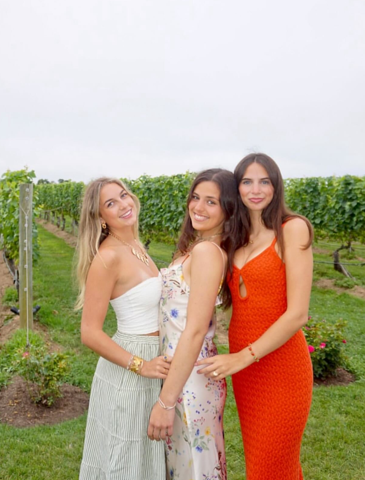 Three members standing in front of trees