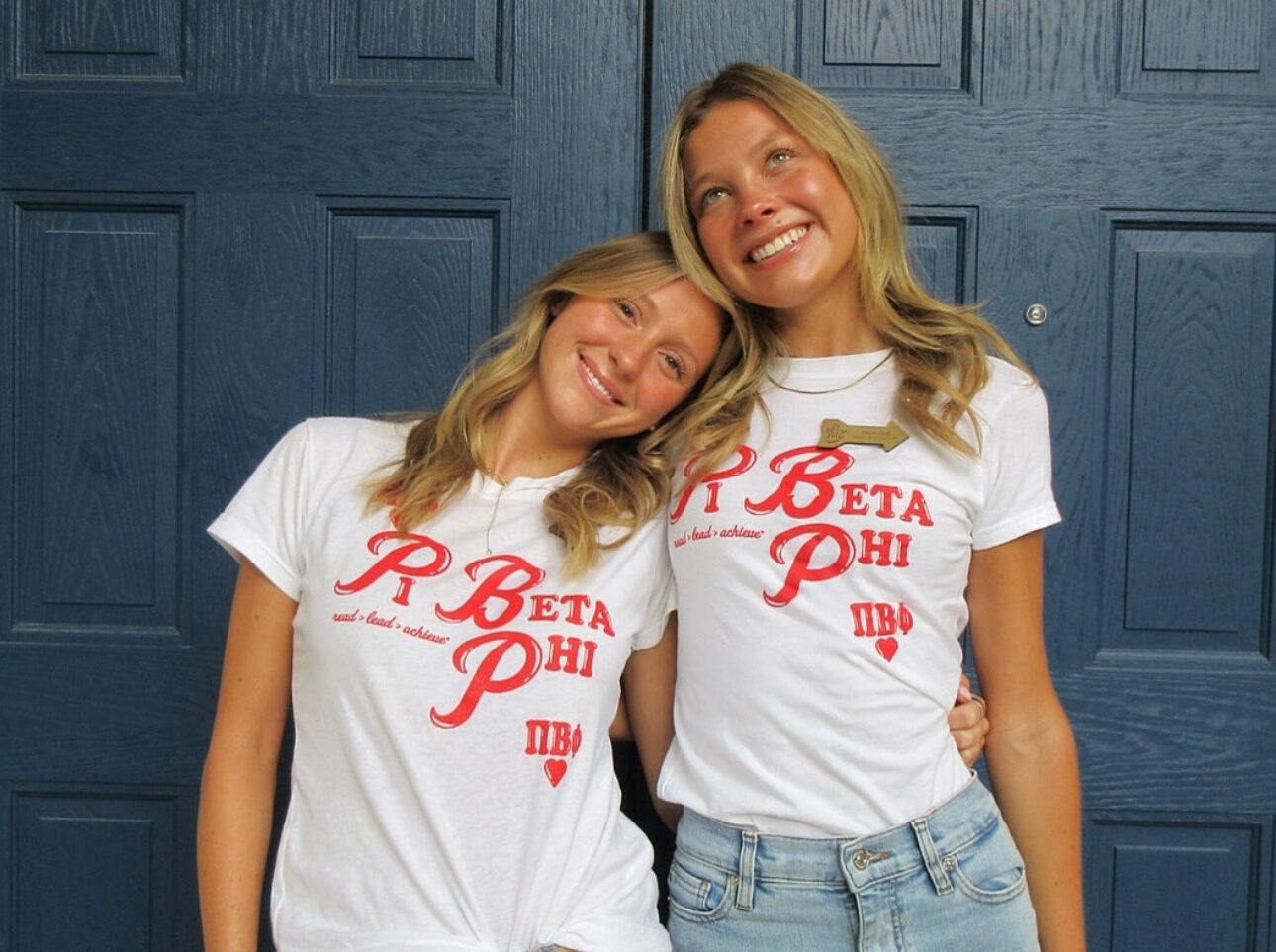 Two members wearing matching white shirts that say Pi Beta Phi in red