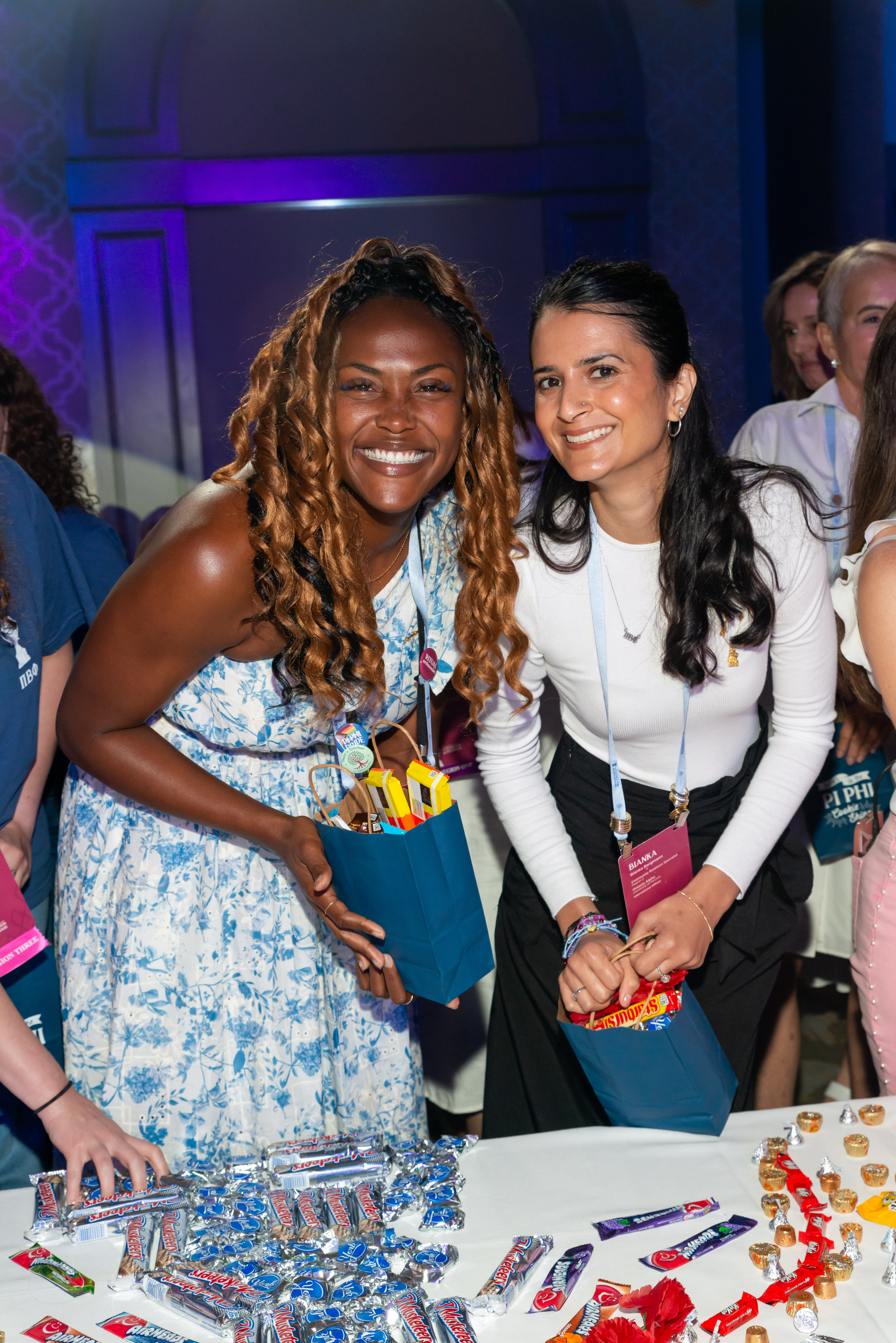 Two members holding bags filled with candy