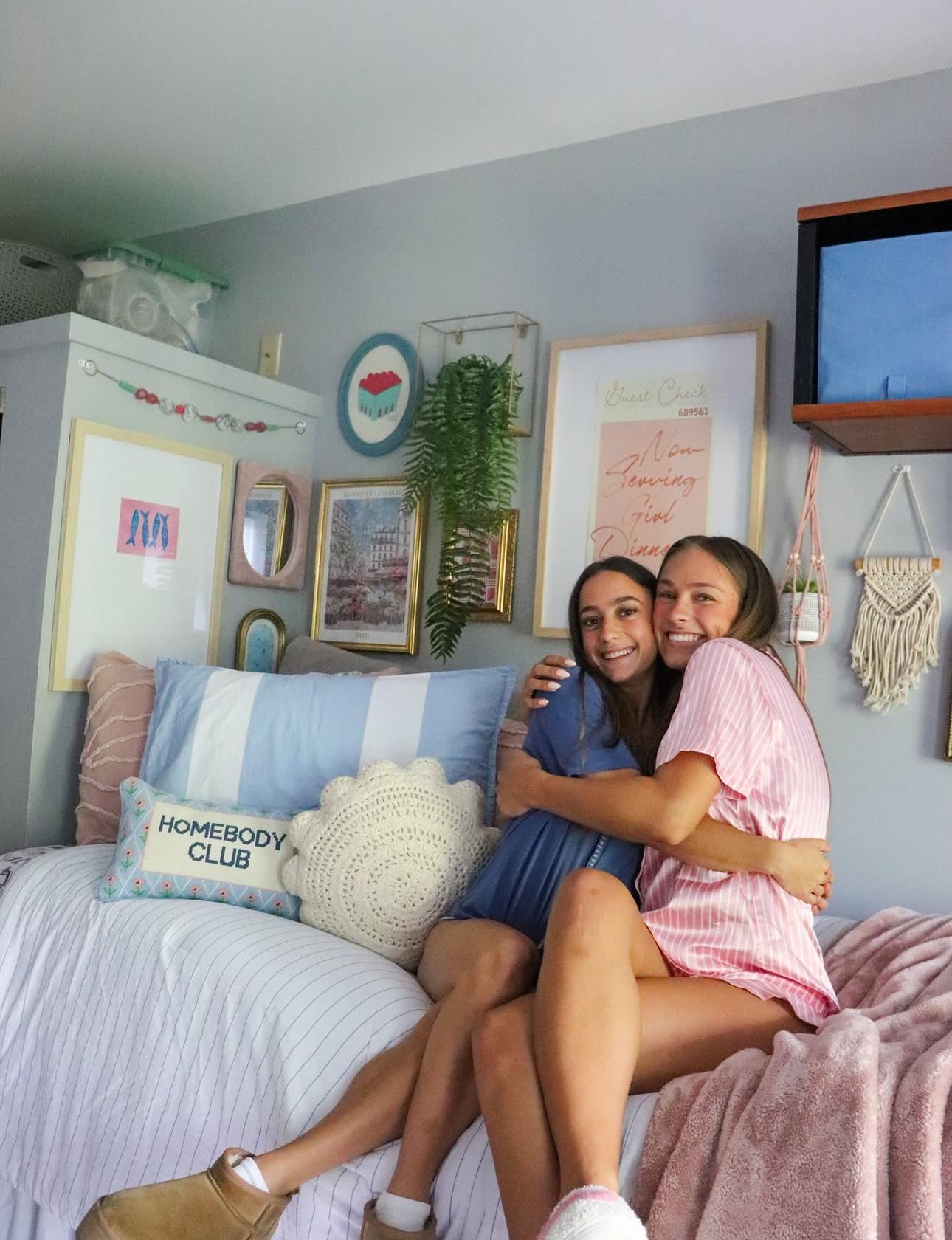 Two members wearing pajamas and sitting on a bed