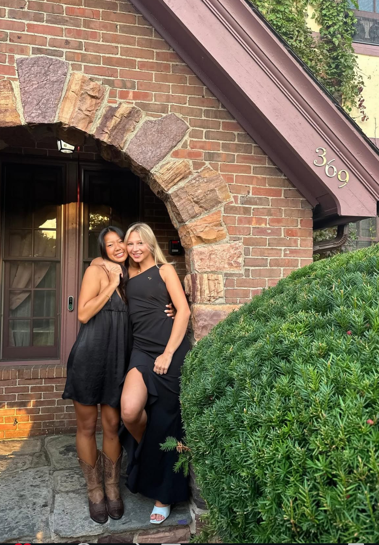 Two members wearing black on the front porch of the chapter house