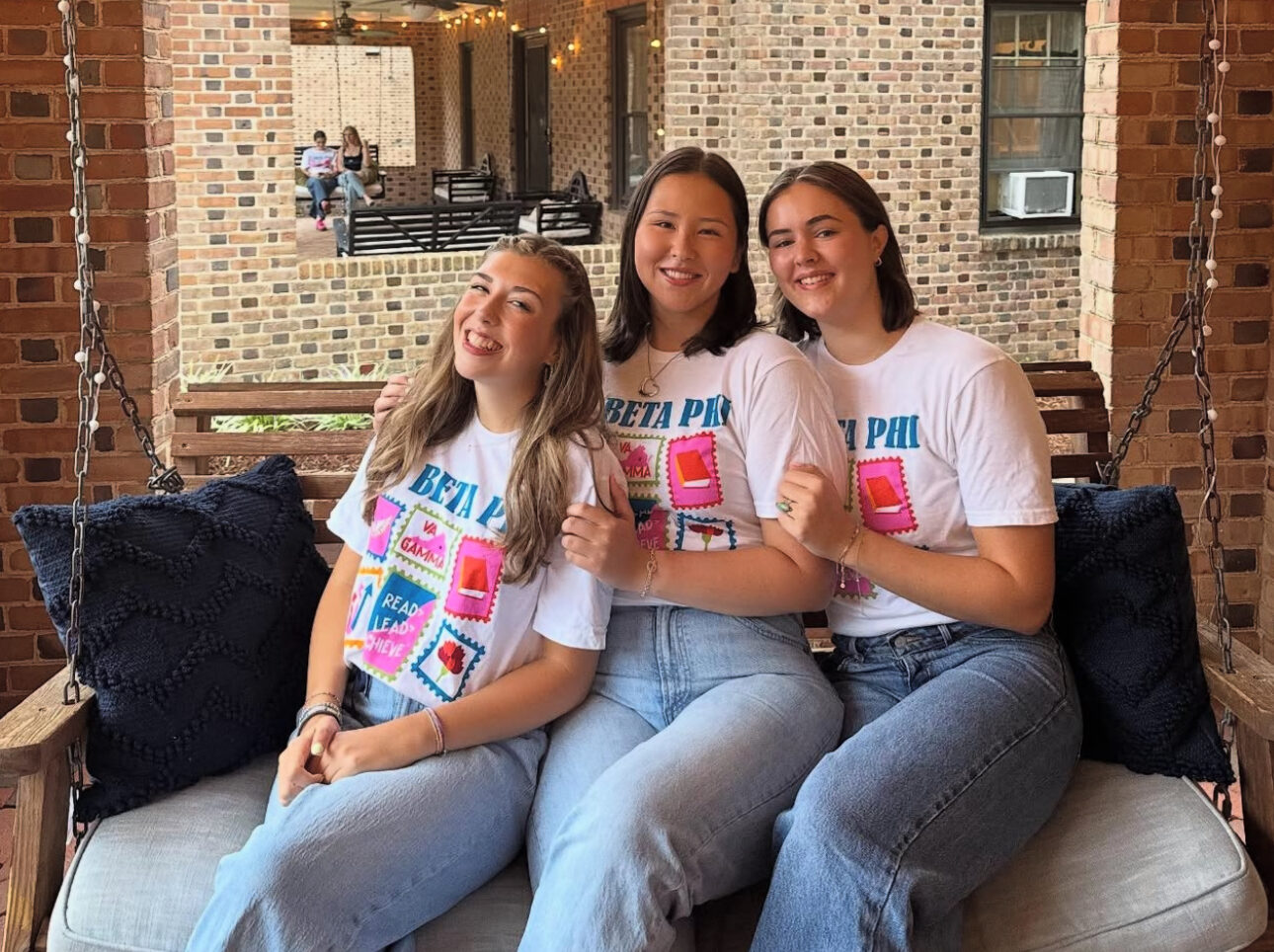 Three members sitting on a front porch
