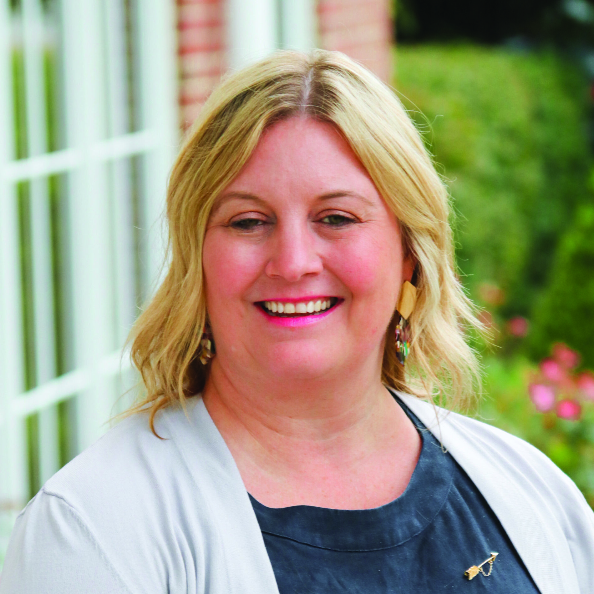 Professional headshot of Marnie Lee wearing a gray cardigan and black blouse